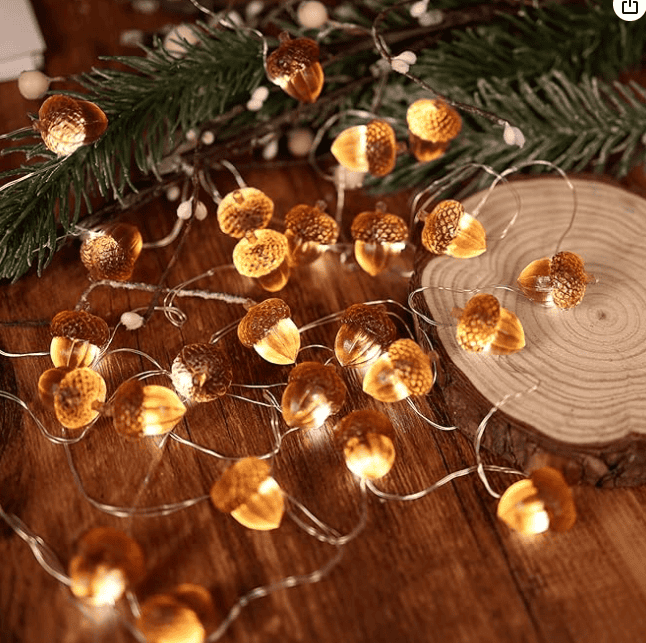 Warm acorn-shaped twinkle lights strung along a mantel, creating a cozy, nature-inspired ambiance perfect for holiday decor in an Airbnb living room.