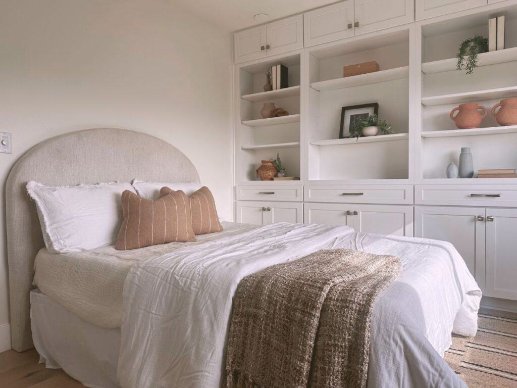 Compact Airbnb bedroom with creative storage solutions and cozy decor.